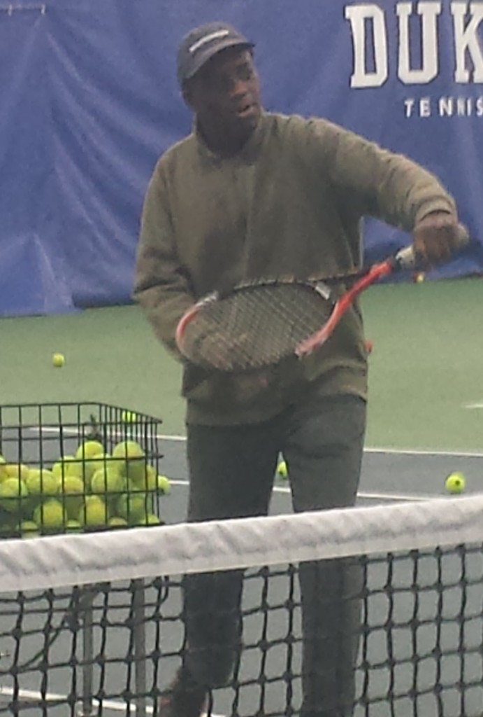 John Mclean giving a tennis lesson to kids