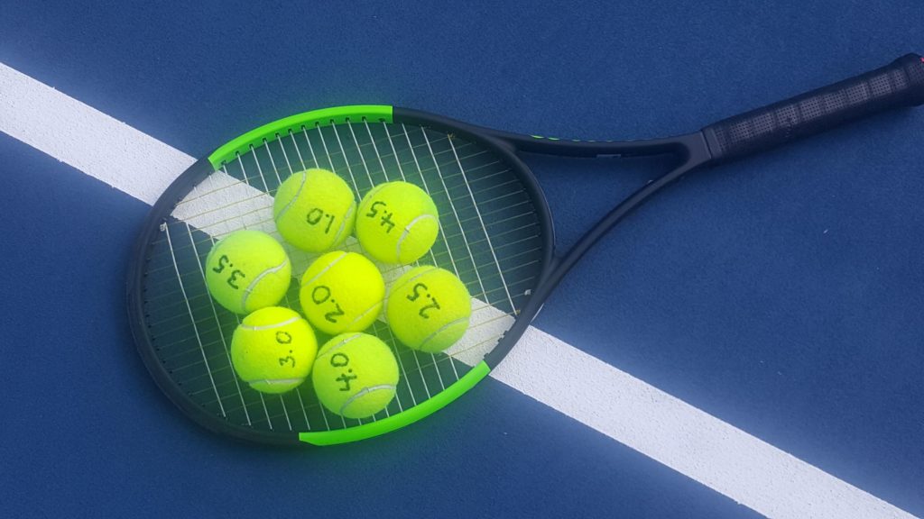 Tennis racquet with tennis balls that have ratings